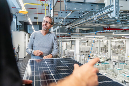 Engineer discussing photovoltaic system in modern production hall