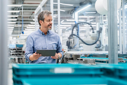 Engineer with tablet monitoring automation in modern factory