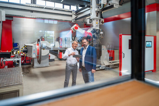 Engineers planning production with digital tablet in modern factory