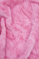 Soft pink fabric lays on a surface showing texture and warmth for various uses in home decor or fashion products © Fleuronica