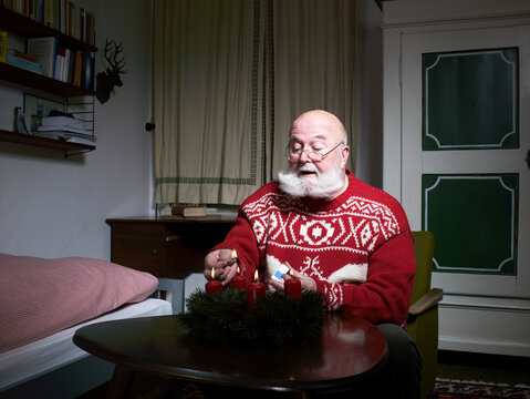 Santa kindling advent wreath indoors preparing for Christmas