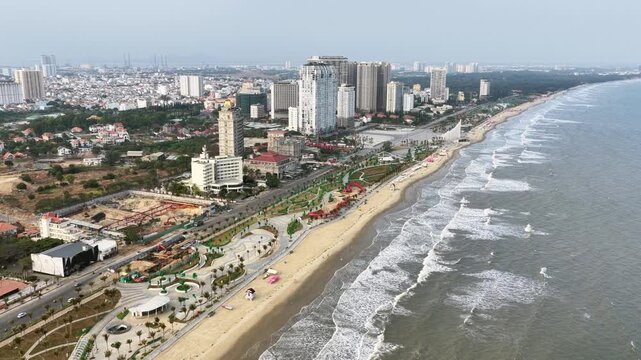 Coastal Vung Tau view from above, with waves, coastline, streets, coconut trees and Tao Phung mountain in Vietnam.