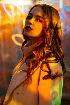 Portrait of a woman with colorful neon glow at night