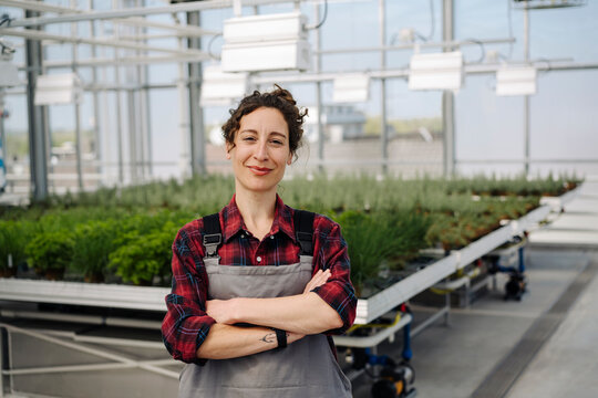 Portrait of confident woman in greenhouse of a gardening shop