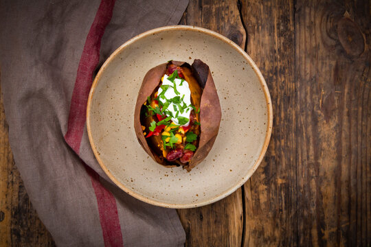 Sweet potato kumpir with chili con carne, sour cream and coriander