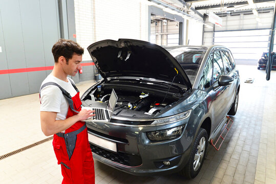 Car mechanic in a workshop using modern diagnostic equipment
