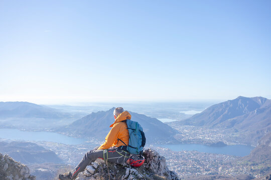 Hiker relaxing on mountain peak enjoying landscape in Lecco Italy