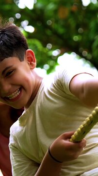 Indian family playing tug of war rassi khech in home garden, spending quality fun time together enjoying outdoor sports, cheerful Asian parents children bonding through traditional backyard activity