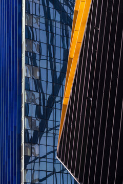 Yellow edge and blue glass facade meet in contrast, where urban architecture turns building reflection into vertical exterior depth
