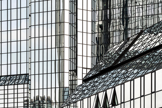 Atrium lines cross a glass facade grid, with windows and reflection giving urban architecture a building structure of exterior depth