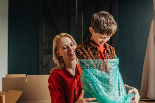 Happy mother with son wrapped in bubble wrap
