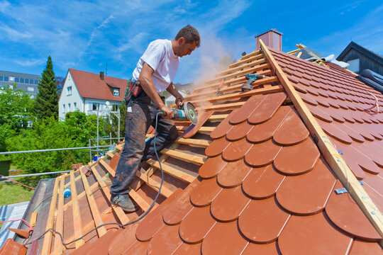 Germany, Baden-Wuerttemberg, Stuttgart, Mid adult man cutting roof tile