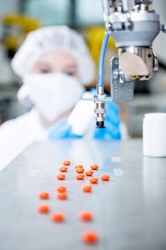 Robot handling tablets with woman in background
