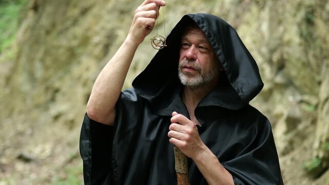 Religious wanderer carefully examines an ancient amulet during a spiritual quest in the forest.