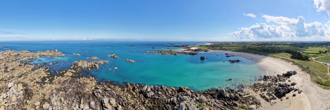 Ein atemberaubender Panorama-Ausblick auf die gesch&uuml;tzte Bucht des Plage de Roc'h ar Gonc mit glasklarem, t&uuml;rkisfarbenem Wasser, feinem Sand und markanten Riffen.