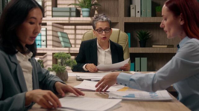 Three multinational businesswomen together discuss work problem planning solution diversity business women talking with papers documents females talk about work trouble teamwork analyzing graphs chart