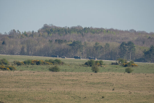 Convoy of logistics vehicles driving an unmade road 
