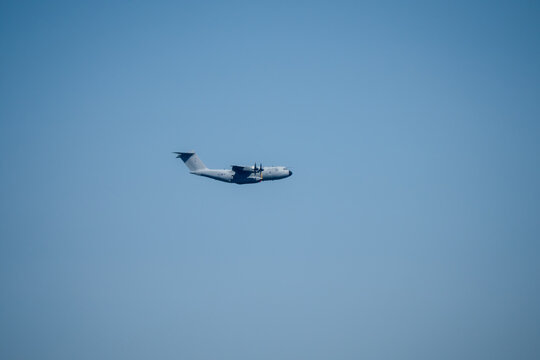 a large grey cargo plane dropping low level parachute cargo
