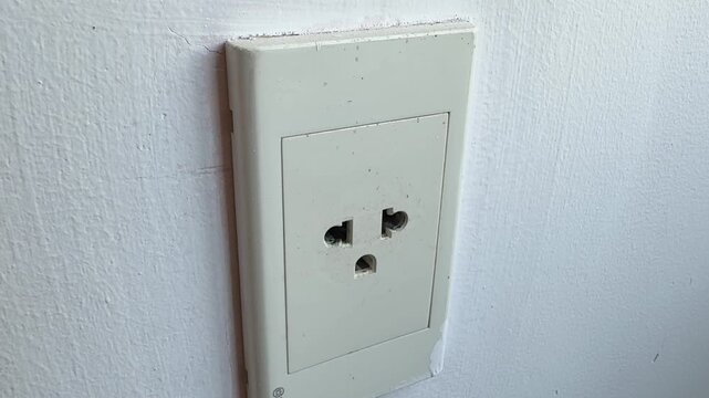 Close-up video of a standard electrical wall outlet in a home or office interior. Everyday utility concept representing electricity, power supply, household infrastructure and modern living.