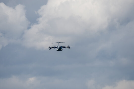 a large grey cargo plane dropping low level parachute cargo