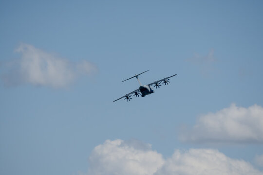 a large grey cargo plane dropping low level parachute cargo