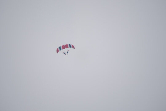 a pair of parachutists link up on descent, formation skydiving
