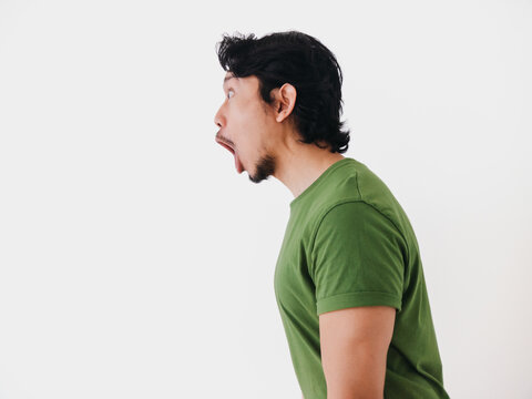 Surprised and shocked face Asian man in green t-shirt isolated on white.