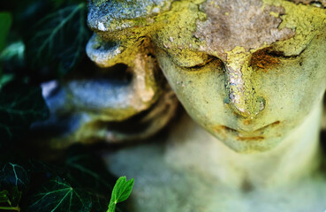 Obraz premium Close-up of a weathered angel statue covered with natural patina.