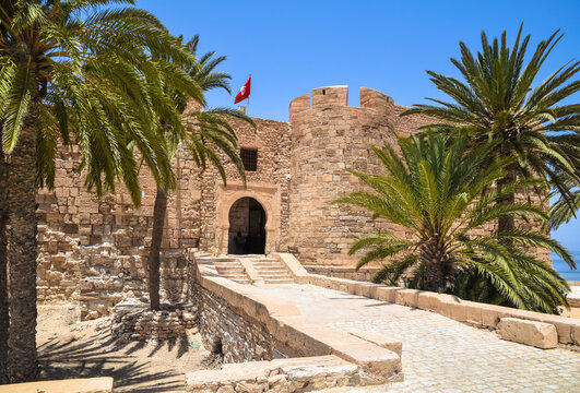 Entrance gate with palm trees at the historic medieval fort of Borj El Kebir (Borj Ghazi Mustapha) in Houmt Souk, Djerba island, Tunisia.