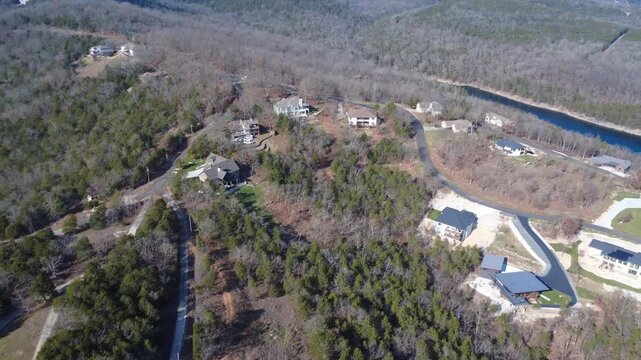 Cinematic drone footage capturing upscale homes nestled among the rolling hills and wooded landscapes near Branson West, Missouri.