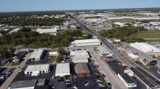 Drone footage of commercial development along Historic Route 66 in Springfield, Missouri, featuring businesses, traffic, warehouses, and urban growth.
