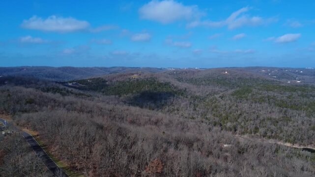 Layer upon layer of forested ridgelines stretch across the Missouri Ozarks as the drone glides above a quiet valley near Branson West. The scene captures the vast scale and timeless beauty