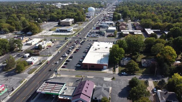 Drone footage along Historic Route 66 in Springfield, Missouri, featuring commercial businesses, traffic, and a prominent city water tower.