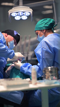 Surgeons Performing Operation in Modern Operating Room With Surgical Team and Medical Equipment