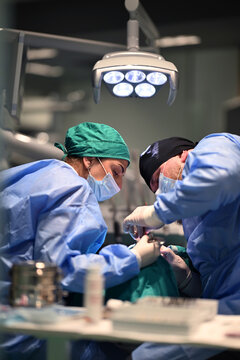 Surgical Team Performing Dental Operation Under Clinical Light in Modern Operating Room