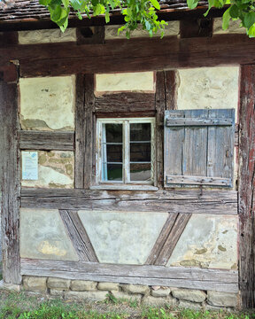 Historische Fachwerkhaus-Fassade mit altem Holzfenster und urigem Fensterladen