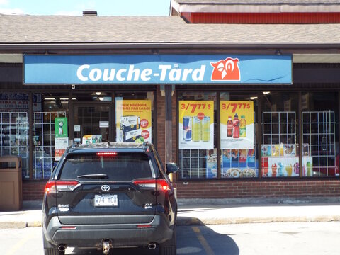 Gatineau, Quebec, Canada &ndash; May 10, 2026: A black Toyota RAV4 is parked in front of a "Couche-Tard" convenience store displaying promotional beverage advertisements outside at 4 Rue d'Orl&eacute;ans.