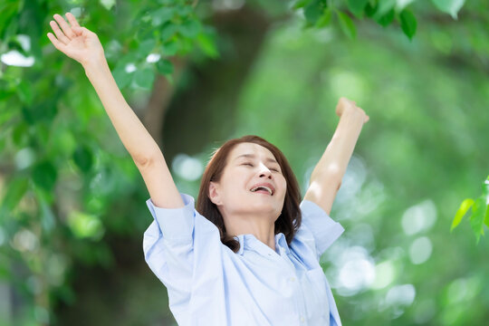 女性　深呼吸　伸び　新緑