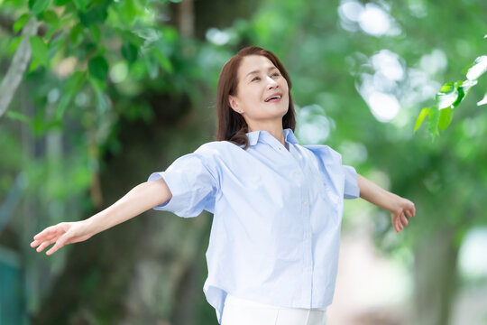 女性　深呼吸　伸び　新緑