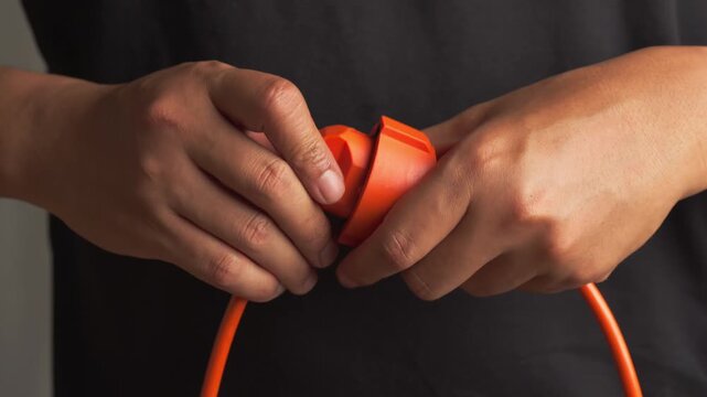 Close up of a man's hand plugging an electrical power plug into a outlet socket
