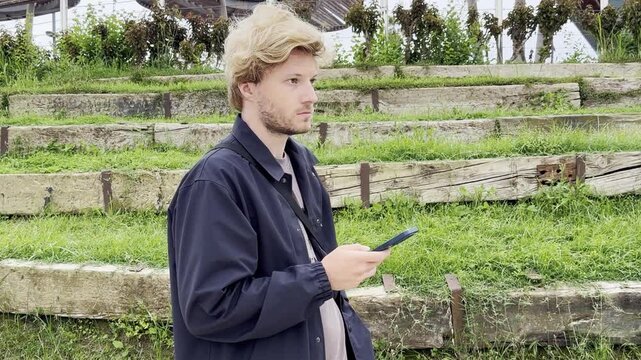 Lifestyle portrait of young man using a smartphone outdoors