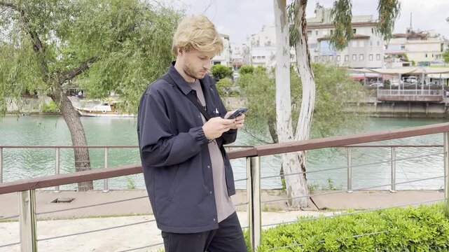Lifestyle portrait of young man using a smartphone outdoors