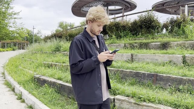 Lifestyle portrait of young man using a smartphone outdoors