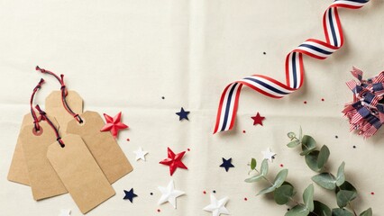 Obraz premium Price tags hang on a light textured background surrounded by festive star confetti and decorative fabric ribbons.