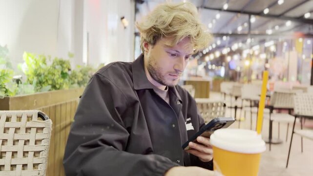 Lifestyle portrait of young man using a smartphone outdoors