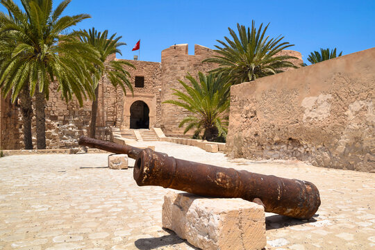 Entrance gate and cannons and palm trees at the historic medieval fort of Borj El Kebir (Borj Ghazi Mustapha) in Houmt Souk, Djerba island, Tunisia.