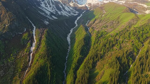 Dramatic alpine valley along the Sar Pass Trek route near Grahan Village, Sosan, and Kasol in Himachal Pradesh, India, with snow fed streams carve through the valley beneath towering Himalayan peaks.