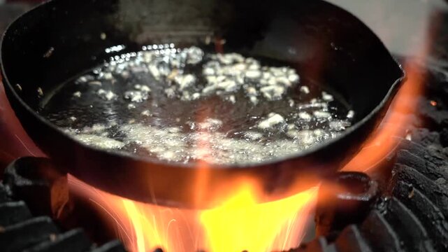 Close up shot of jalebis frying in hot oil during traditional Indian sweet preparation.