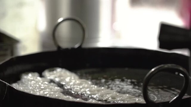 Close up shot of jalebis frying in hot oil during traditional Indian sweet preparation.