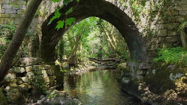 Historical Stone Bridge Of Lumeares Over The Vaos River In Galicia, Spain. Aerial Forward Shot